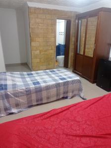 1 dormitorio con cama y pared de ladrillo en Appartement lumineux, en Kouba