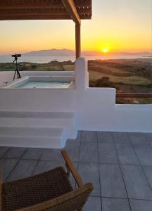a view of the sunset from a house with a camera at Ariadne's Crown Suites Astro Concept Luxury in Vívlos