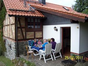 a group of people sitting at a table on a patio at Ferienhaus Harz in Allrode