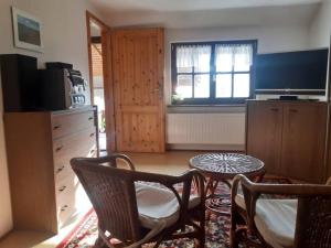 ein Wohnzimmer mit Tisch und Stühlen und einem Fernseher in der Unterkunft Ferienhaus Harz in Allrode