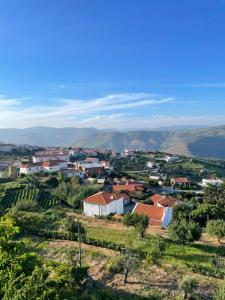 una piccola cittadina su una collina con montagne sullo sfondo di Casa da Quinta - T1 a Tabuaço Altre 3 foto