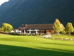 una casa con un grande campo verde di fronte a una montagna di Ferienwohnung Pia a Wald am Arlberg