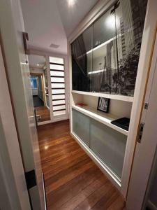 een hal van een huis met houten vloeren en een spiegel bij Flat VII - Apto dentro do Hotel - Rua Quintana in Sao Paulo