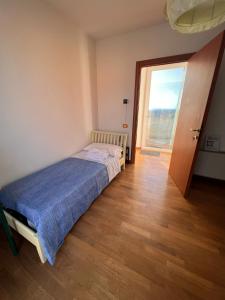 a small bedroom with a bed and a large window at Villa delle Gazanie -Camera in villa -Vista panoramica sul Golfo in Quartu SantʼElena