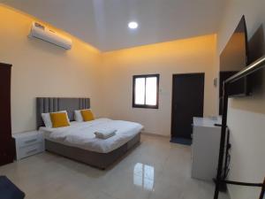 a bedroom with a bed and a television in it at EK Homes in Ras al Khaimah