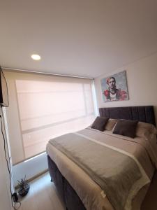 Un dormitorio con una cama grande y una ventana en Estudio en edificio con piscina climatizada, en Bogotá
