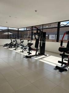 un gimnasio con una fila de cintas de correr y bicicletas estáticas en Estudio en edificio con piscina climatizada, en Bogotá