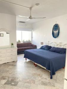 a bedroom with a blue bed and a couch at CASA BLANCA in Cancún +2 photos