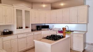 a kitchen with white cabinets and a stove top oven at CASA BLANCA in Cancún