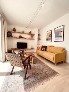 uma sala de estar com um sofá e uma mesa em Edles Apartment in Architektenvilla mit großem Pool, Sauna, Dachterrasse und malerischem Garten em Pataias