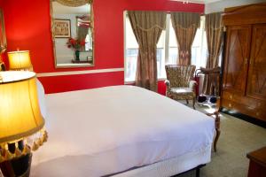 a bedroom with a white bed and a red wall at Yosemite Bug Rustic Mountain Resort in Midpines