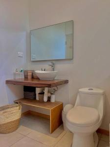 une salle de bain avec des toilettes blanches et un lavabo dans l'établissement Cozy Cottage Hilltop near Conchal - Casa Vala, à Matapalo