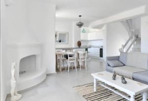 a white living room with a couch and a table at Villa Galano PAROS GREECE in Ambelas