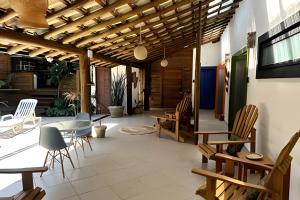 a living room with a table and chairs at Vila Saíra, chalé Laranja, 50m da praia in Ilhabela