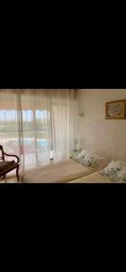 1 dormitorio con 1 cama grande y ventana en Cosy unoverlooked apartment with swimming pool, en Mandelieu-la-Napoule