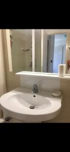 een badkamer met een witte wastafel en een spiegel bij Cosy unoverlooked apartment with swimming pool in Mandelieu-la-Napoule