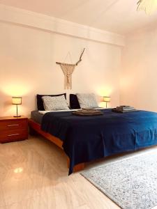 a bedroom with a bed with blue sheets and two lamps at Edles Apartment in Architektenvilla mit großem Pool, Sauna, Dachterrasse und malerischem Garten in Pataias +20 photos