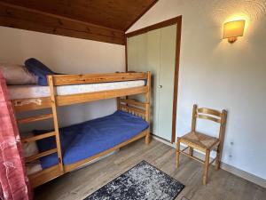 a bedroom with two bunk beds and a chair at Appartement Notre-Dame-de-Bellecombe, 2 pièces, 6 personnes - FR-1-595-27 in Notre-Dame-de-Bellecombe