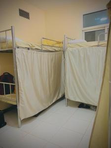 two bunk beds covered with sheets in a room at Dubai Homes near ADCB METRO STATION in Dubai
