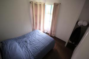a bedroom with a blue bed and a window at Urumayu Eco lodge in Urubamba