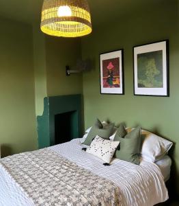 MirfieldSpa Garden Cottage - Upper Hopton的一间卧室配有一张床和一个吊灯