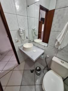 y baño con aseo, lavabo y espejo. en Pousada Cantinho D'Abrantes - Próximo as Melhores Praias de Ilhabela - Veloso e Curral, en Ilhabela