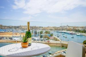 een fles wijn en twee glazen op een tafel bij Stunning Apartment with Valletta and Harbour Views in Sliema