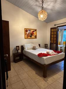 a bedroom with a bed with a red blanket on it at Pousada Flor de Porto in Porto De Galinhas