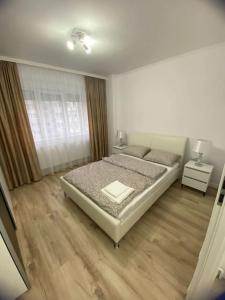a white bedroom with a bed and a window at Apartament Daria in Timişoara +11 photos