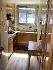 une cuisine avec une table, un évier et une fenêtre dans l'établissement Calme et vue exceptionnelle!, à Banyuls-sur-Mer