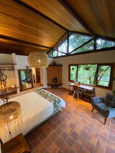 una camera con un grande letto in una stanza con finestre di CasAlê Come&Dorme a São Pedro da Serra