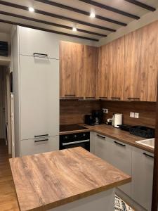 cocina con armarios de madera y encimera en Thess Comfort House A, en Tesalónica