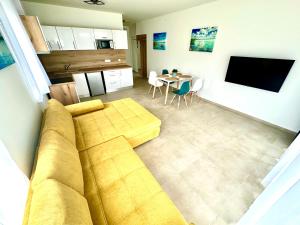 a living room with a couch and a table at Ady Corner Prémium Apartmanok - Siófok in Siófok