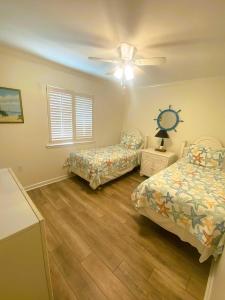 - une chambre avec 2 lits et un ventilateur de plafond dans l'établissement Lighthouse Point Rental 37B, à Tybee Island