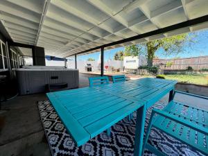 einen blauen Picknicktisch und Stühle auf einer Terrasse in der Unterkunft SeaWorld Retreat: 4BR House/Jacuzzi/BBQ in San Diego