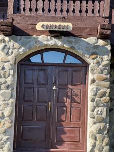 - une porte dans un bâtiment en pierre avec un panneau au-dessus dans l'établissement La patru daci, à Ocna Şugatag