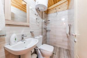La salle de bains est pourvue de toilettes blanches et d'un lavabo. dans l'établissement Villa del Mar San Pietro, à Durrës