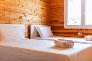 - 2 lits dans une chambre dotée de murs en bois dans l'établissement Villa del Mar San Pietro, à Durrës