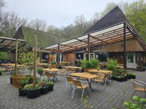 a patio with tables and chairs and a building at Het Hertenbos Chalet 136 - Bos- Groene Oase- Rustmoment- Zwembad in Durbuy