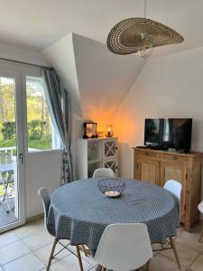 a dining room with a table and chairs at 11 Les Pins Penchés in Neufchâtel-Hardelot