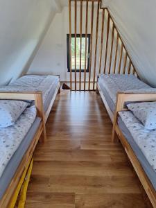 two beds in a room with a staircase at Kucica Hrasno in Breza