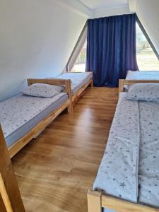 Zimmer mit 3 Etagenbetten und einem Fenster in der Unterkunft Kucica Hrasno in Breza