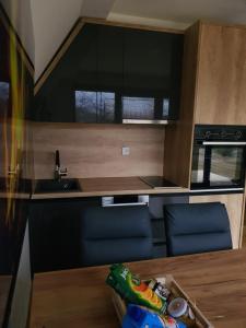 eine Küche mit einem Holztisch und blauen Stühlen in einem Wohnwagen in der Unterkunft Kucica Hrasno in Breza