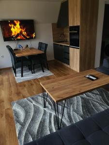 ein Wohnzimmer mit einem Tisch und einem Kamin in der Unterkunft Kucica Hrasno in Breza