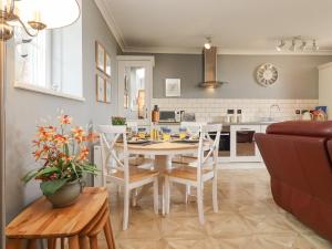 cocina y comedor con mesa y sillas en The Tack Room, en Lydney