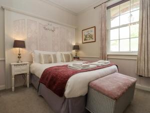 a bedroom with a large bed and a window at The Tack Room in Lydney