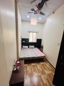 a room with a bed and a ceiling fan at Hotel Shankar Gaura Palace in Ujjain