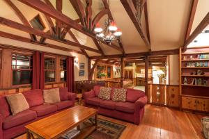 a living room with red couches and a table at Arrowhead Pine Rose Cabins in Twin Peaks