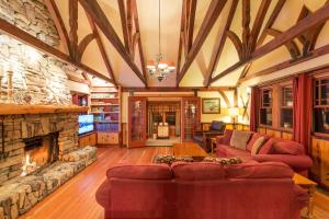 a living room with couches and a stone fireplace at Arrowhead Pine Rose Cabins in Twin Peaks