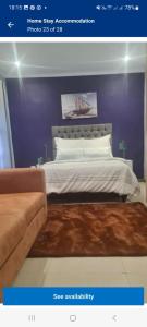 a bedroom with a bed with a purple wall at AR : Homestay Accommodation Goodwood in Cape Town